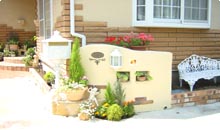 塗り壁に穴を開け、鉢植えを置くスペースを作り、限られたスペースでもガーデニングを楽しめる空間を演出。