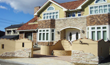 門の張り材は家と同じものを使用して統一感を持たせ、塗り壁の上に4色の笠木を用いている。。アプローチも2つ作り豪華で飽きのこないデザイン。